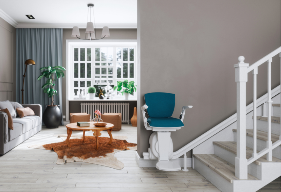 a living room with a large window and a centrally located round coffee table in front of a couch.  Outside the room, on the opposite wall is a set of stairs with an automated chair lift attached.